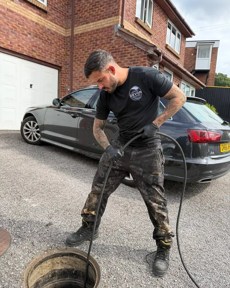 Devon Drainage Services engineer clearing a blocked drain on a driveway in Devon